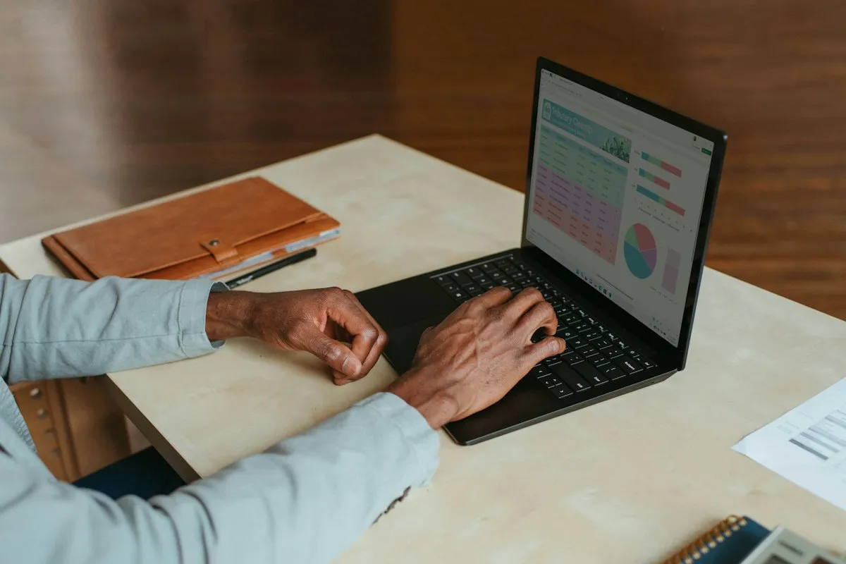 Osoba upravlja web stranicom putem laptopa za radnim stolom